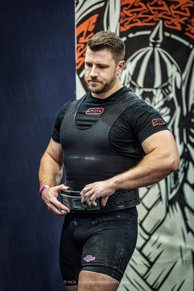 David Stanton fastening his lifting belt before a powerlifting lift