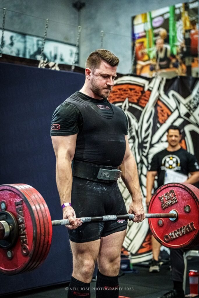 David Stanton finishing a heavy deadlift at a powerlifting meet
